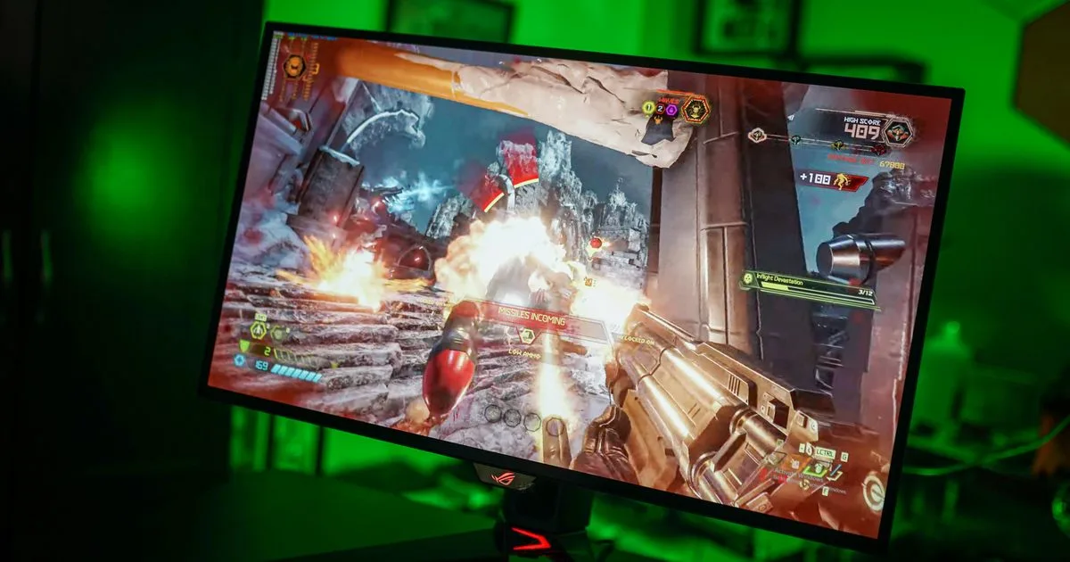 Asus ROG Swift PG27AQDP gaming monitor with slim bezels and RGB lighting on desk